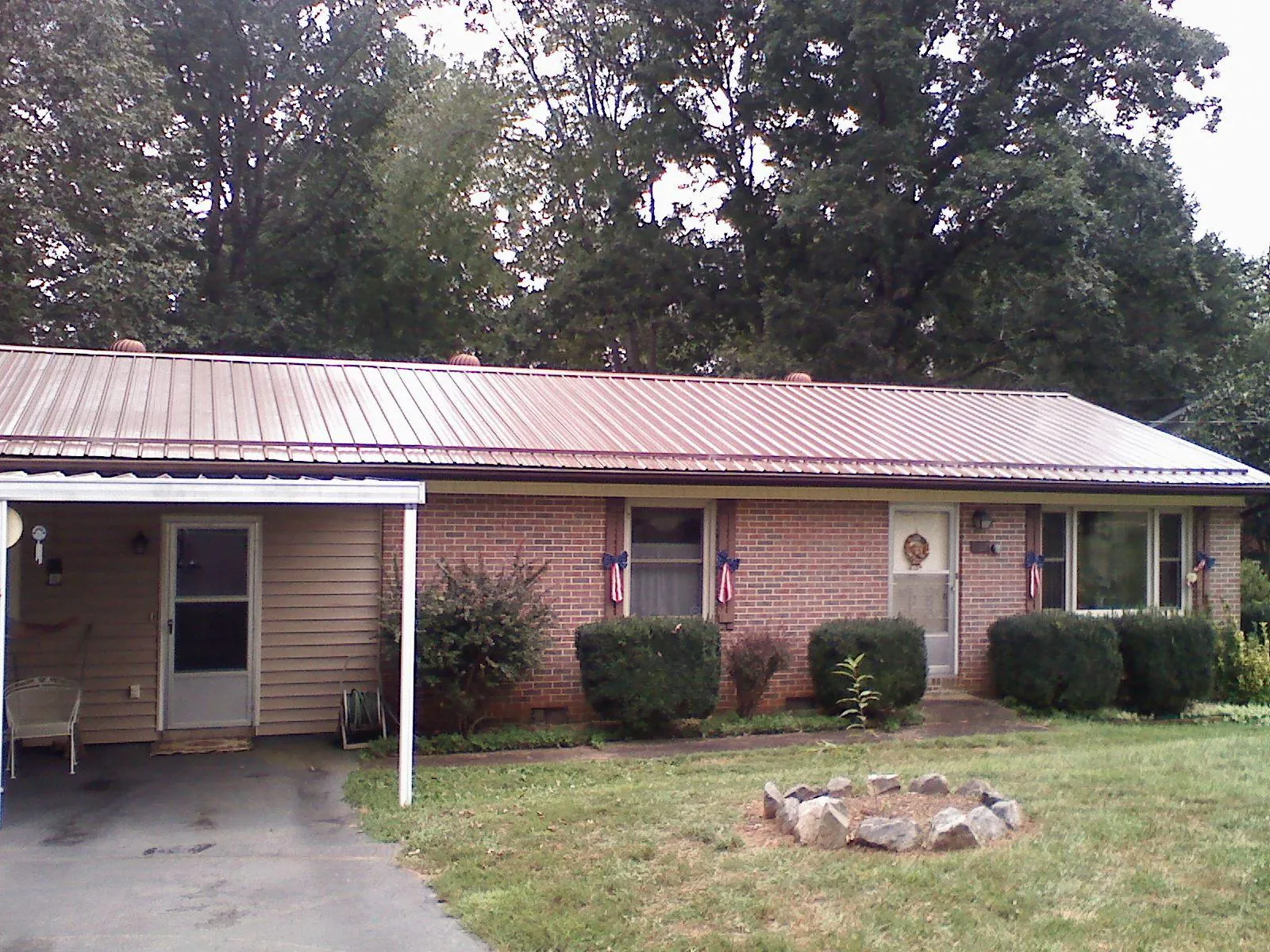 Bronze metal roof and carport on a brick ranch home — Roof Repair work by our crew in Lineville