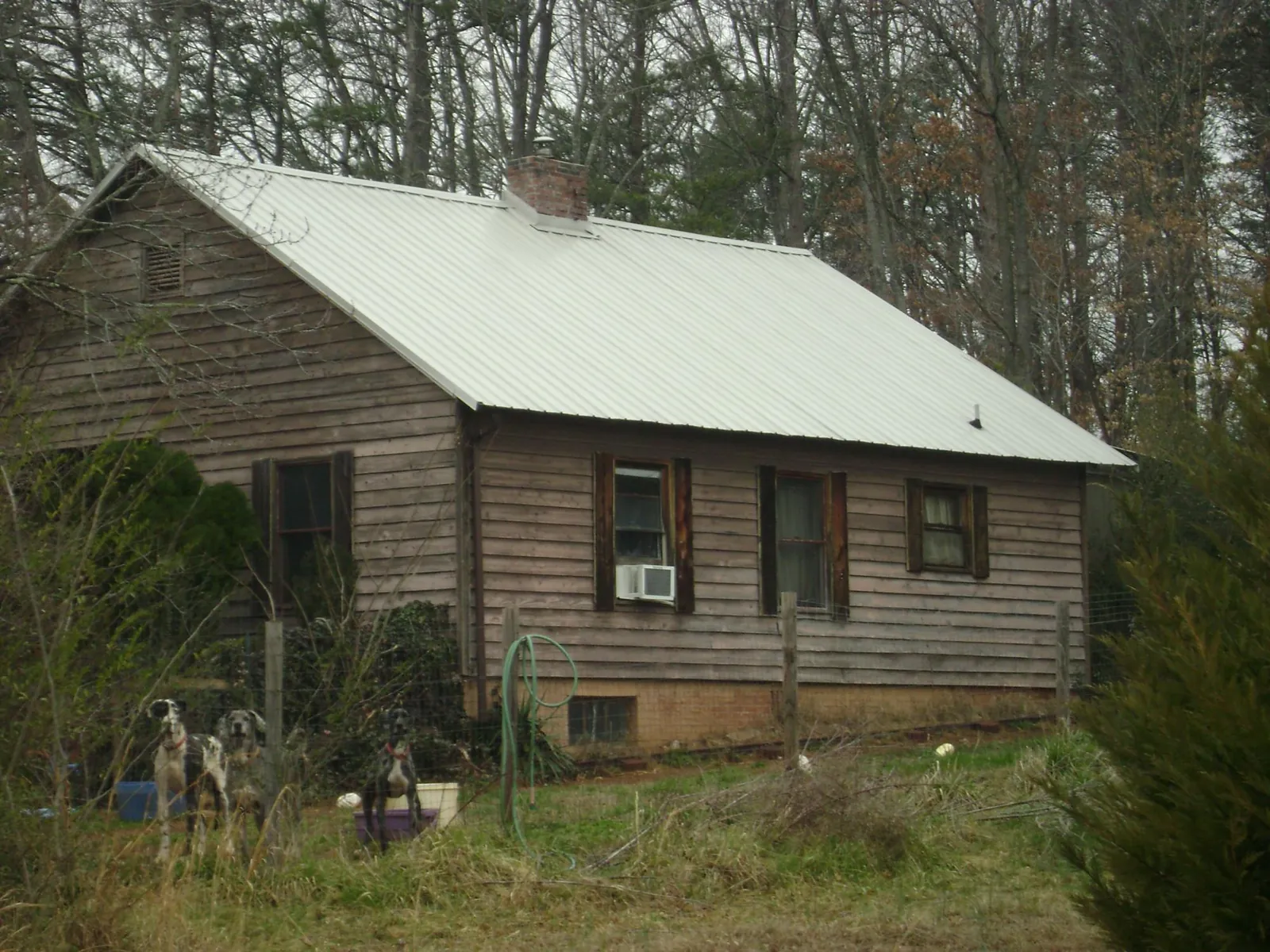White metal roof on an old wood sided farmhouse, from a Metal Roof Installation job in Lineville